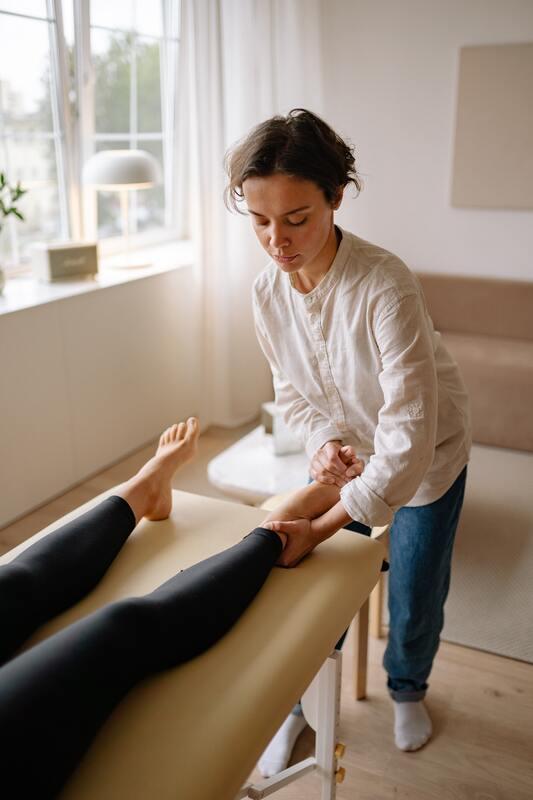 A chiropractor holds a patient's foot during a chiropractic adjustment